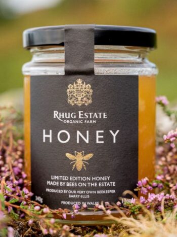 Rhug Estate Limited Edition Honey Jar sitting among flowers.