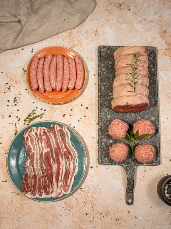 a beef roasting joint with sausage stuffing, bacon and chipolatas