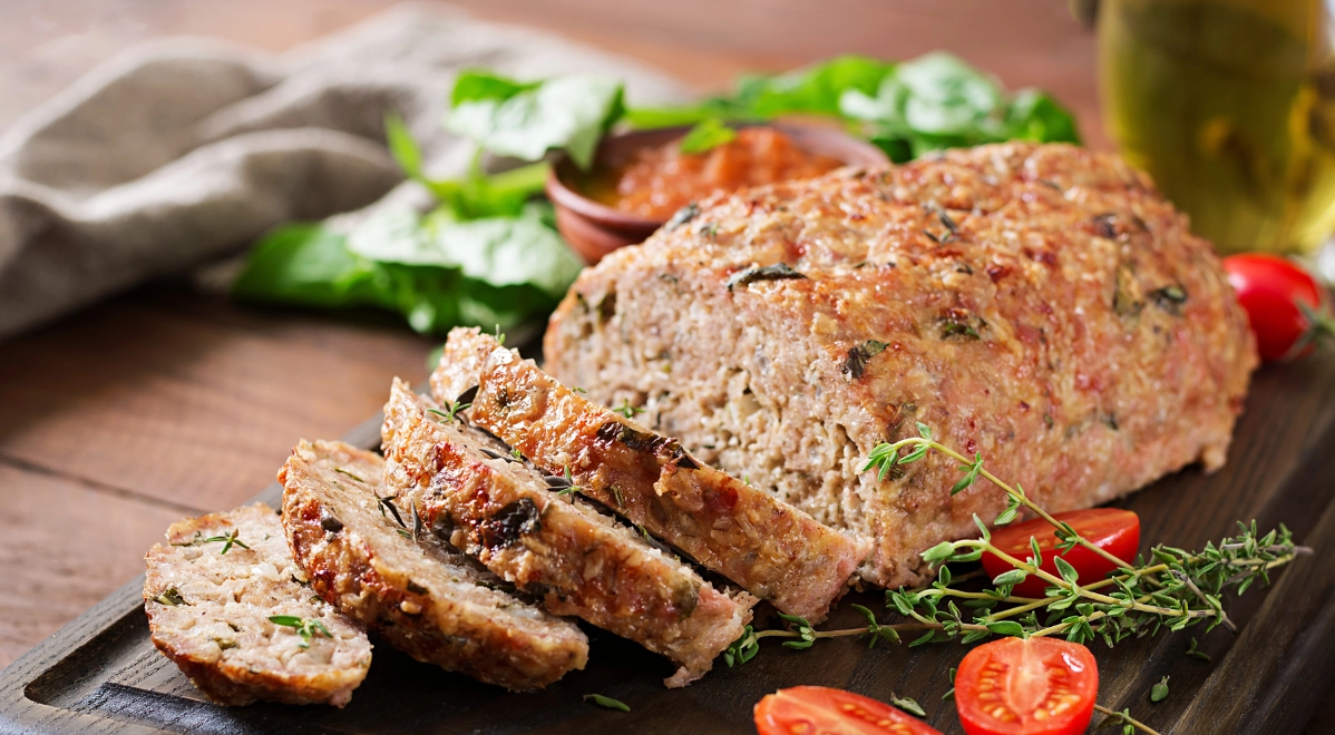 A whole turkey meatloaf with several slices